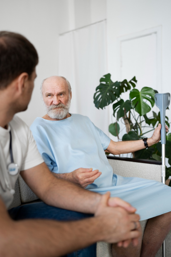 An older patient sitting with a clinician